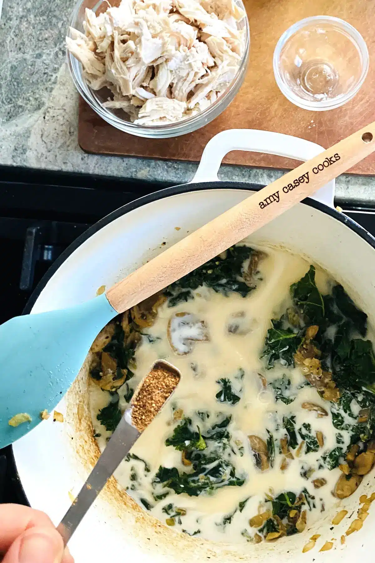 adding nutmeg to kale sauce.