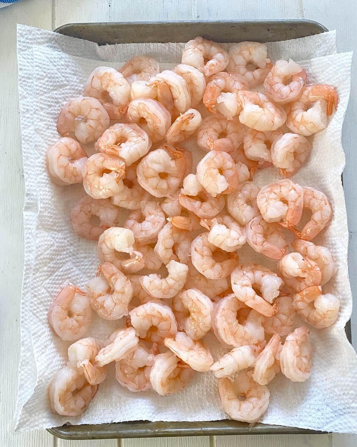 drying cooked shrimp on paper towels.