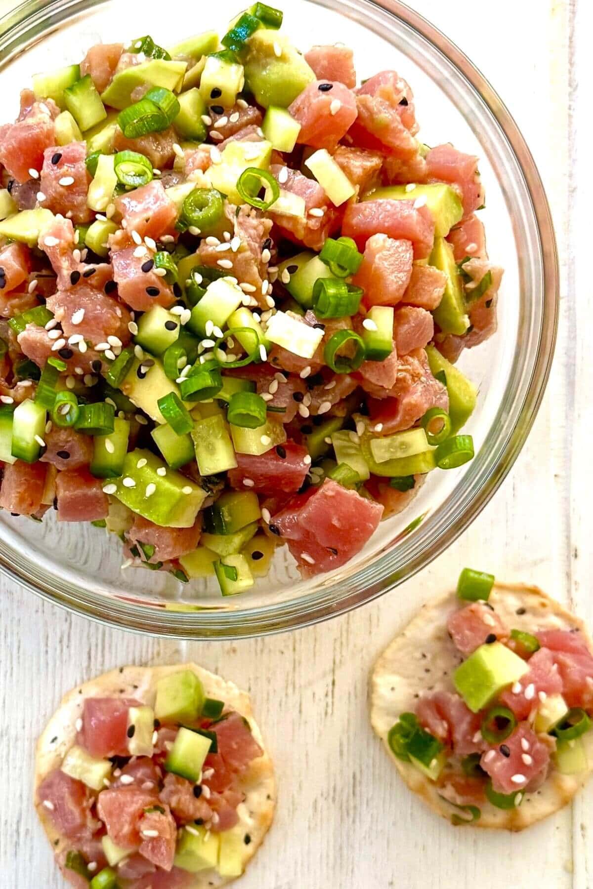 two crackers with tuna ceviche and a bowl of ceviche.