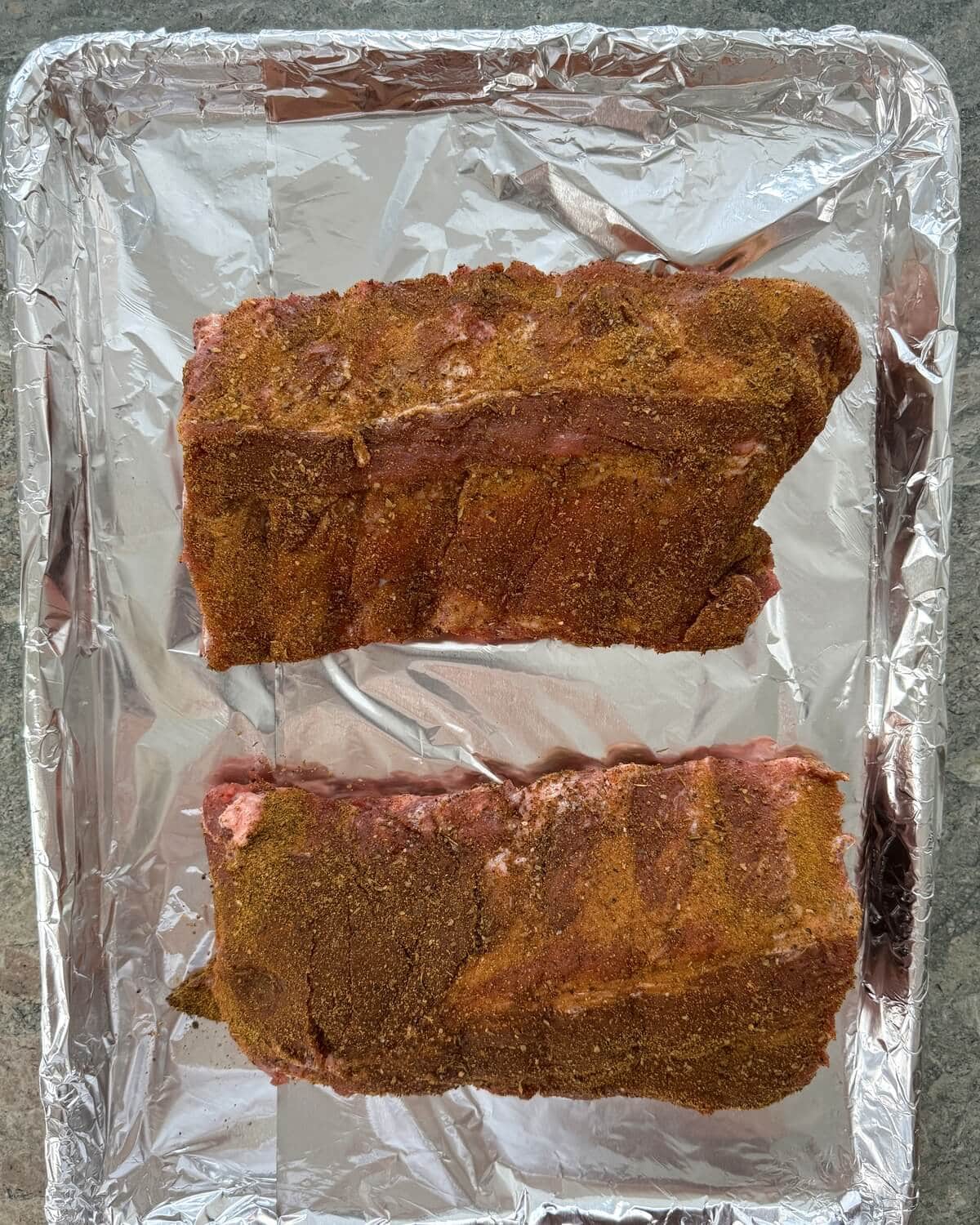 Seasoned baby back ribs that are uncooked.