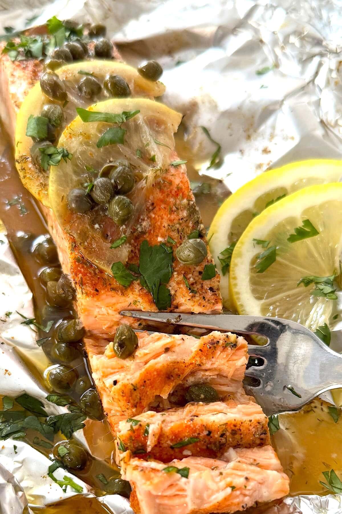 Baked salmon in foil with lemon, capers and wine.