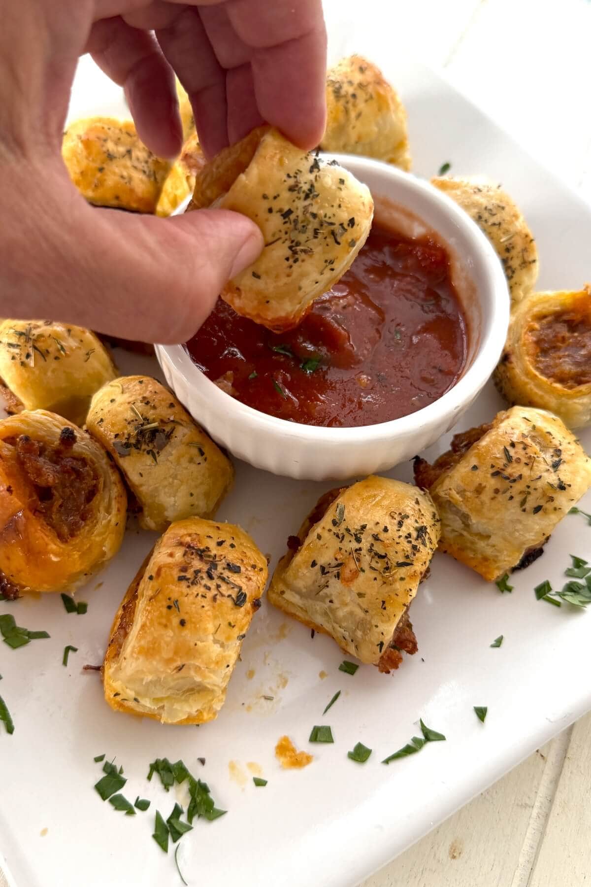 Dipping a homemade sausage roll in marinara sauce.