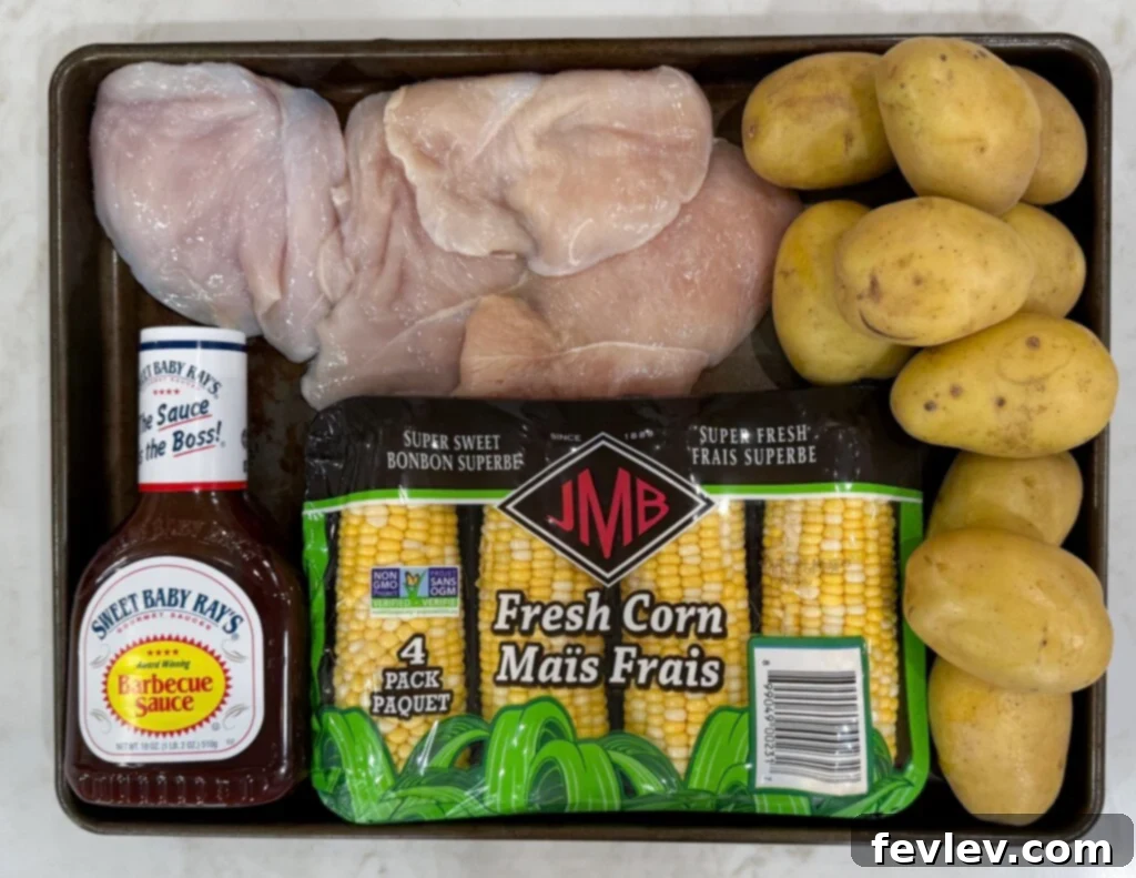 Barbecue Chicken Sheet Pan Feast 2 sheet pan bbq chicken ingredients - fresh potatoes, corn, olive oil, seasonings, and chicken breast on a cutting board