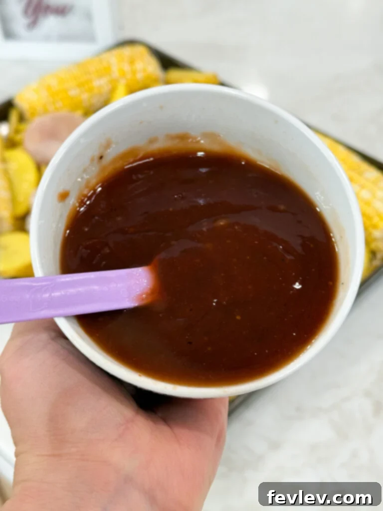 Barbecue Chicken Sheet Pan Feast 4 bbq mixture - small bowl with BBQ sauce, honey, and lime juice being whisked together