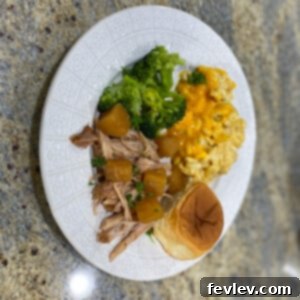 Delicious Slow Cooker Pineapple Shredded Pork served over rice, garnished with fresh cilantro