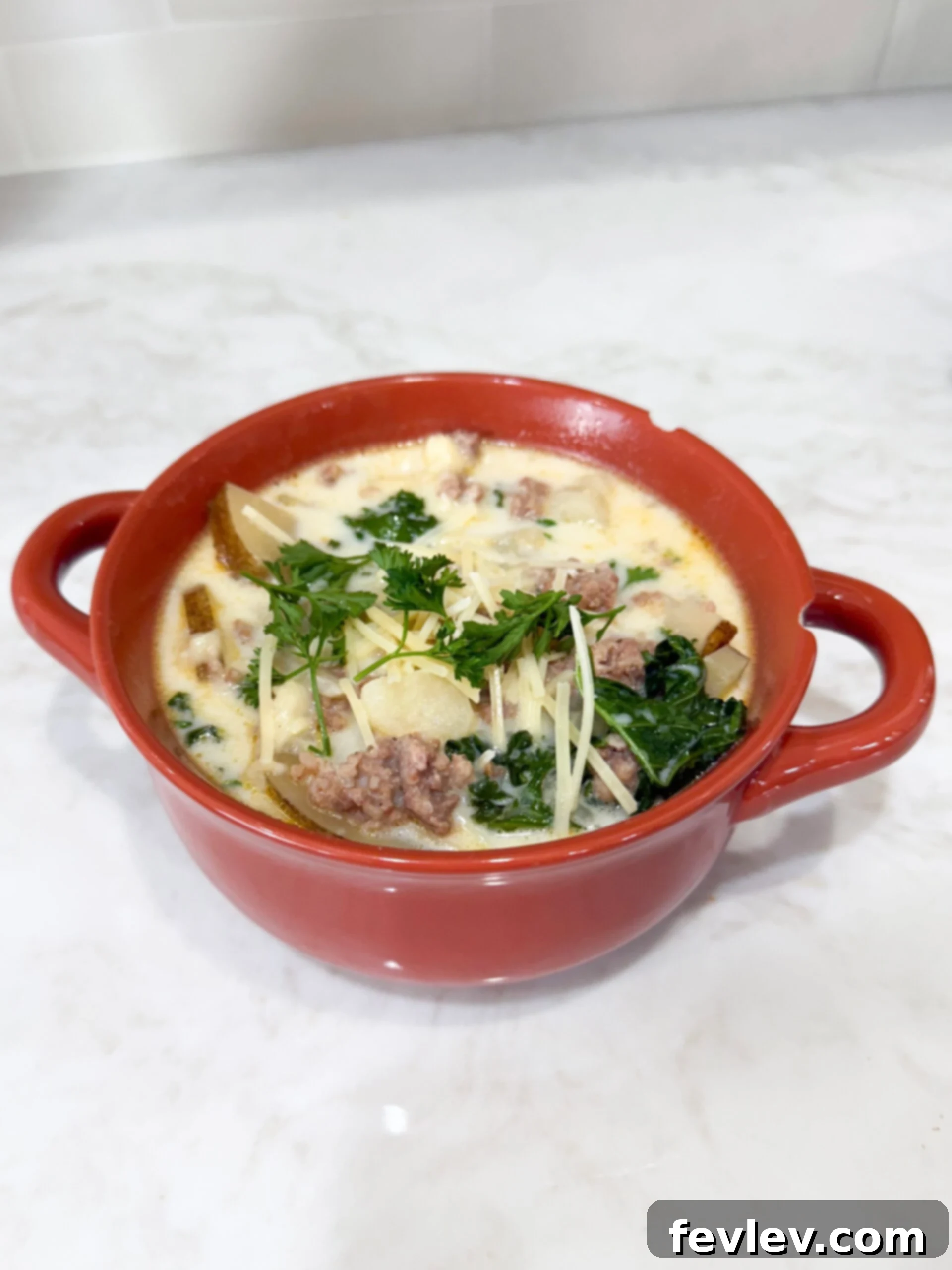 Easy Slow Cooker Zuppa Toscana 8 A freshly served bowl of Slow Cooker Zuppa Toscana Soup topped generously with grated Parmesan cheese, ready to be enjoyed.
