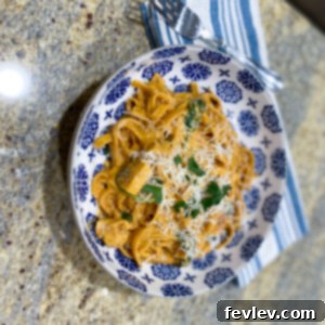 One-Pot Tuscan Chicken Pasta 2 A vibrant, creamy one-pot Tuscan chicken pasta dish, garnished with fresh spinach and sun-dried tomatoes.