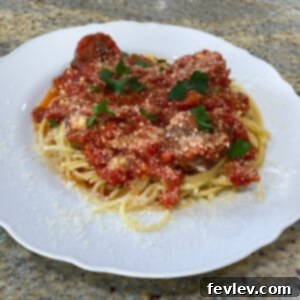 Rich, slow-simmered homemade bulk marinara sauce in a pot with fresh basil garnish