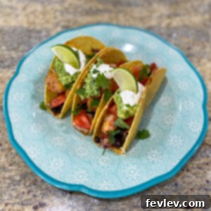 Crispy baked chicken tacos filled with seasoned chicken, black beans, Rotel, and melted cheese