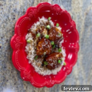 Delicious Slow Cooker Sesame Chicken served over rice with green onions