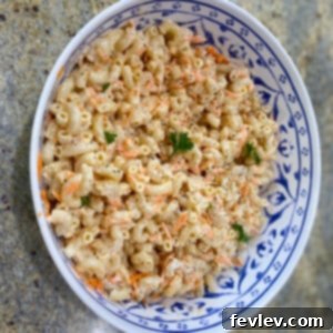 A bowl of delicious Hawaiian Mac Salad, garnished with fresh parsley, ready to be served.
