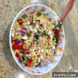 Vibrant Orzo Feta Pasta Salad with cherry tomatoes, cucumber, red onion, and fresh basil, tossed in a light dressing.