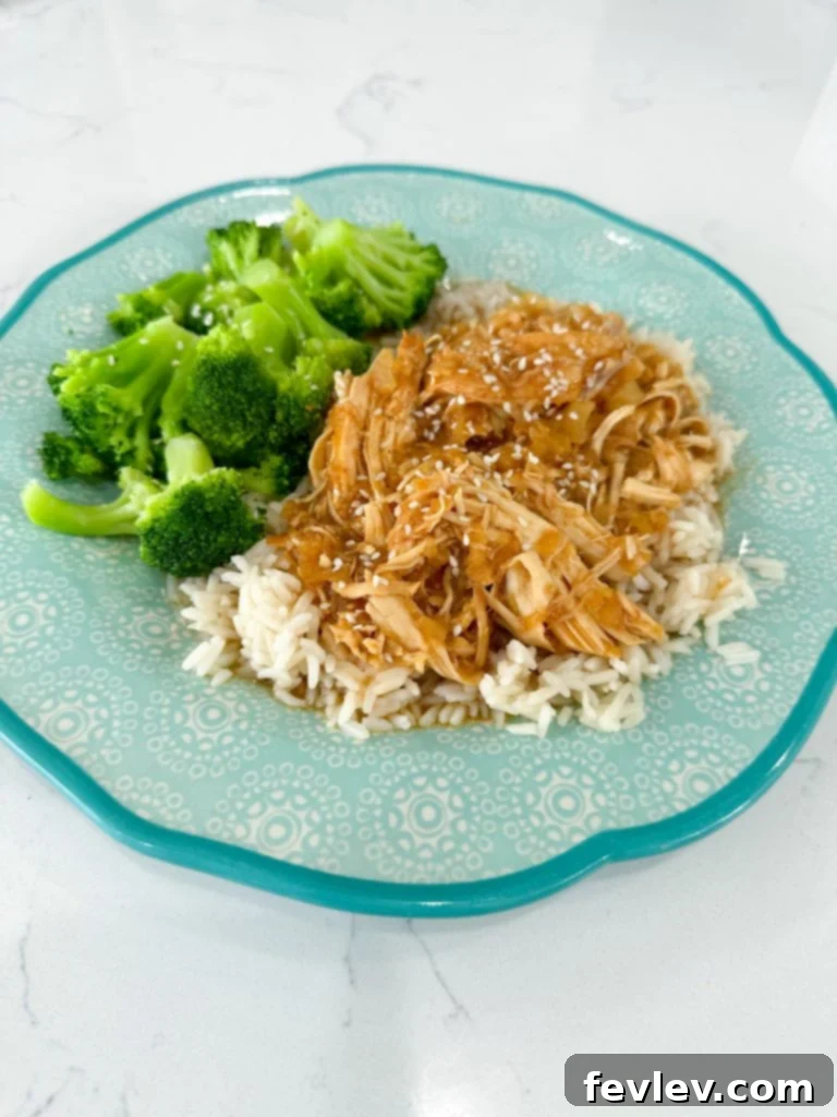 A close-up of a delicious Slow Cooker Pineapple Barbecue Chicken sandwich on a bun with coleslaw, ready to be eaten.