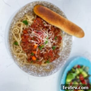 A delicious bowl of 20-Minute Spaghetti Bolognese garnished with fresh herbs, ready to be served.