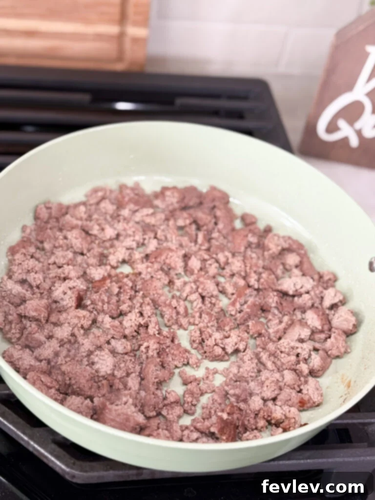 Weeknight Sloppy Joe Winner 4 Ground meat cooking in a large white skillet on the stove top