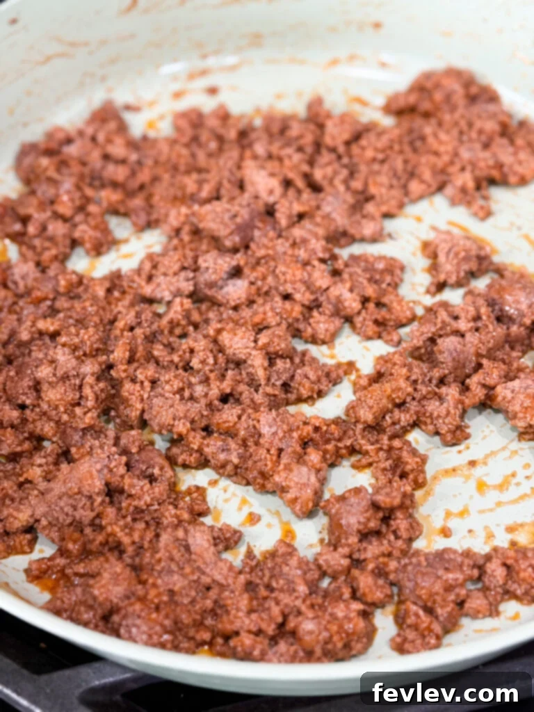 Weeknight Sloppy Joe Winner 5 Ground meat cooked in sloppy joe sauce in a large white skillet on the stove top
