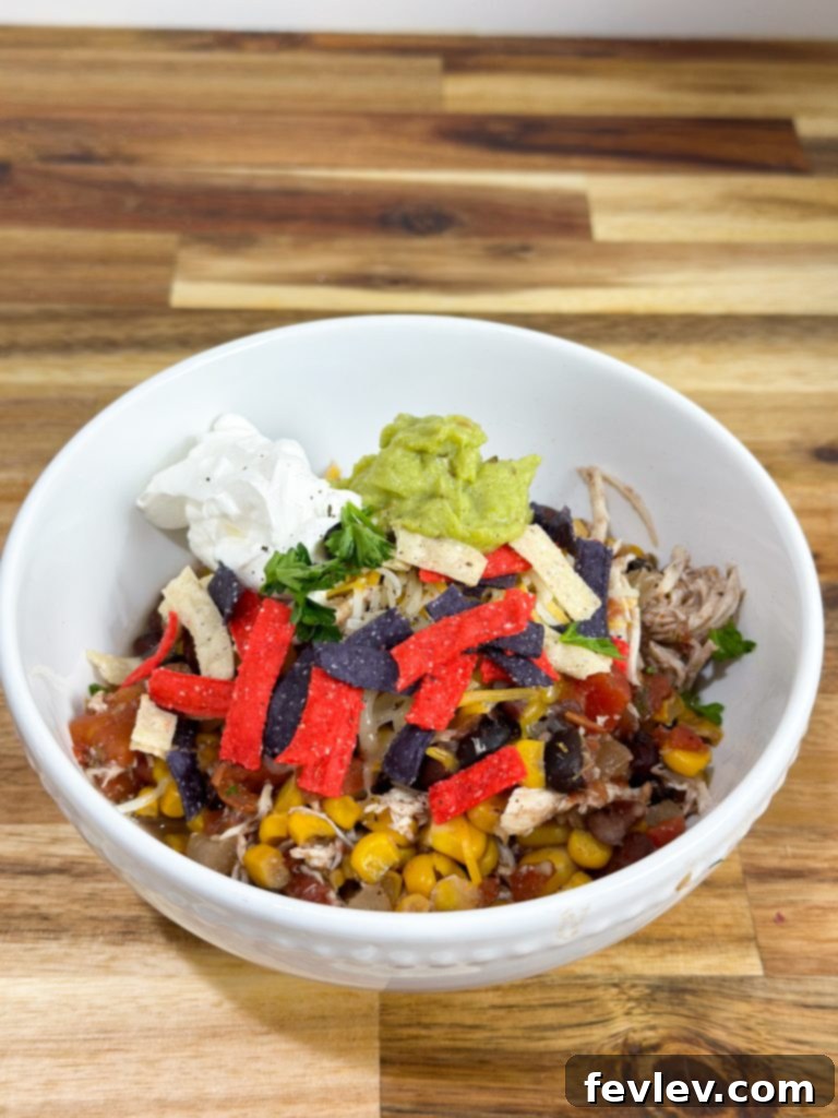 One-Pot Chicken Burrito Bowls 3 A close-up of a delicious slow cooker chicken burrito bowl with shredded chicken, corn, black beans, and fresh cilantro.