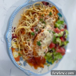 Delicious Slow Cooker Chicken Parmesan served over spaghetti