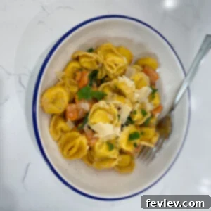 Creamy Sweet Potato Cheese Tortellini garnished with fresh herbs