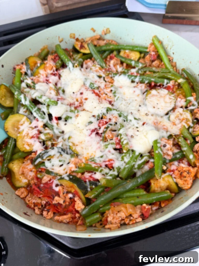 Wholesome Low-Carb Turkey and Veggie Skillet 2 Seasoned low-carb turkey vegetable skillet with melted parmesan cheese