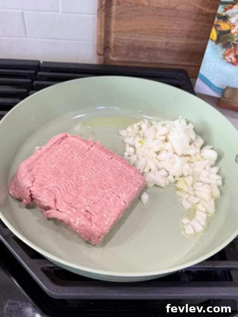 Wholesome Low-Carb Turkey and Veggie Skillet 4 Adding ground turkey and diced onion to a hot skillet