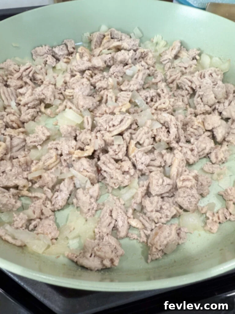 Wholesome Low-Carb Turkey and Veggie Skillet 5 Browning ground turkey with a spatula in a pan