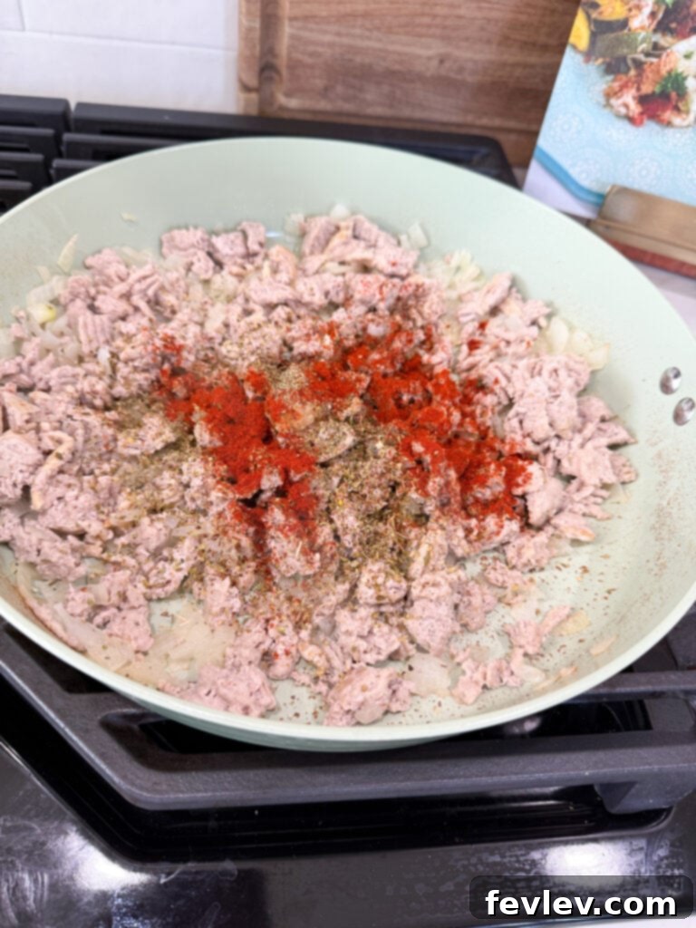 Wholesome Low-Carb Turkey and Veggie Skillet 6 Seasoning browned ground turkey with garlic, salt, pepper, Italian seasoning, oregano, and paprika in a pan