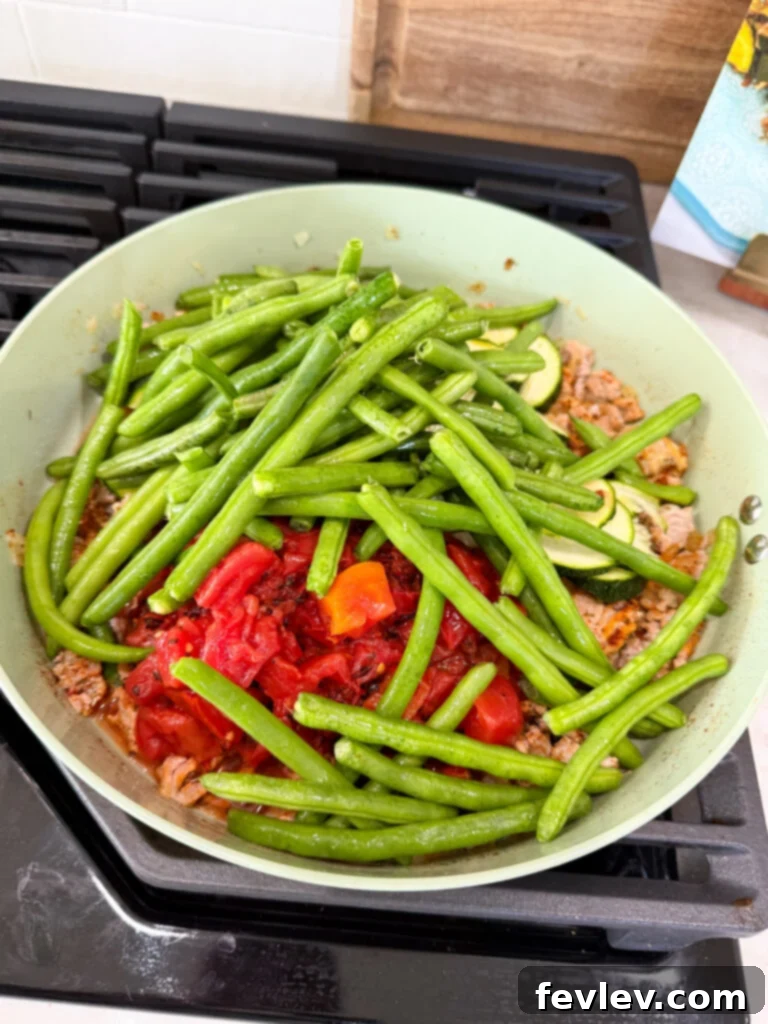 Wholesome Low-Carb Turkey and Veggie Skillet 7 Cooking fresh green beans and zucchini with ground turkey and spices in a skillet