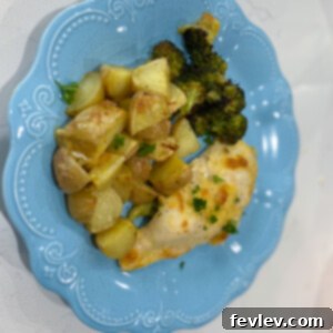 Crispy Parmesan Crusted Chicken with roasted potatoes and broccoli on a sheet pan
