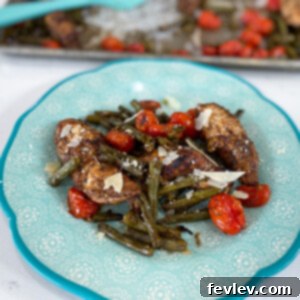 Delicious Tuscan Balsamic Chicken with roasted green beans and cherry tomatoes, garnished with Parmesan cheese