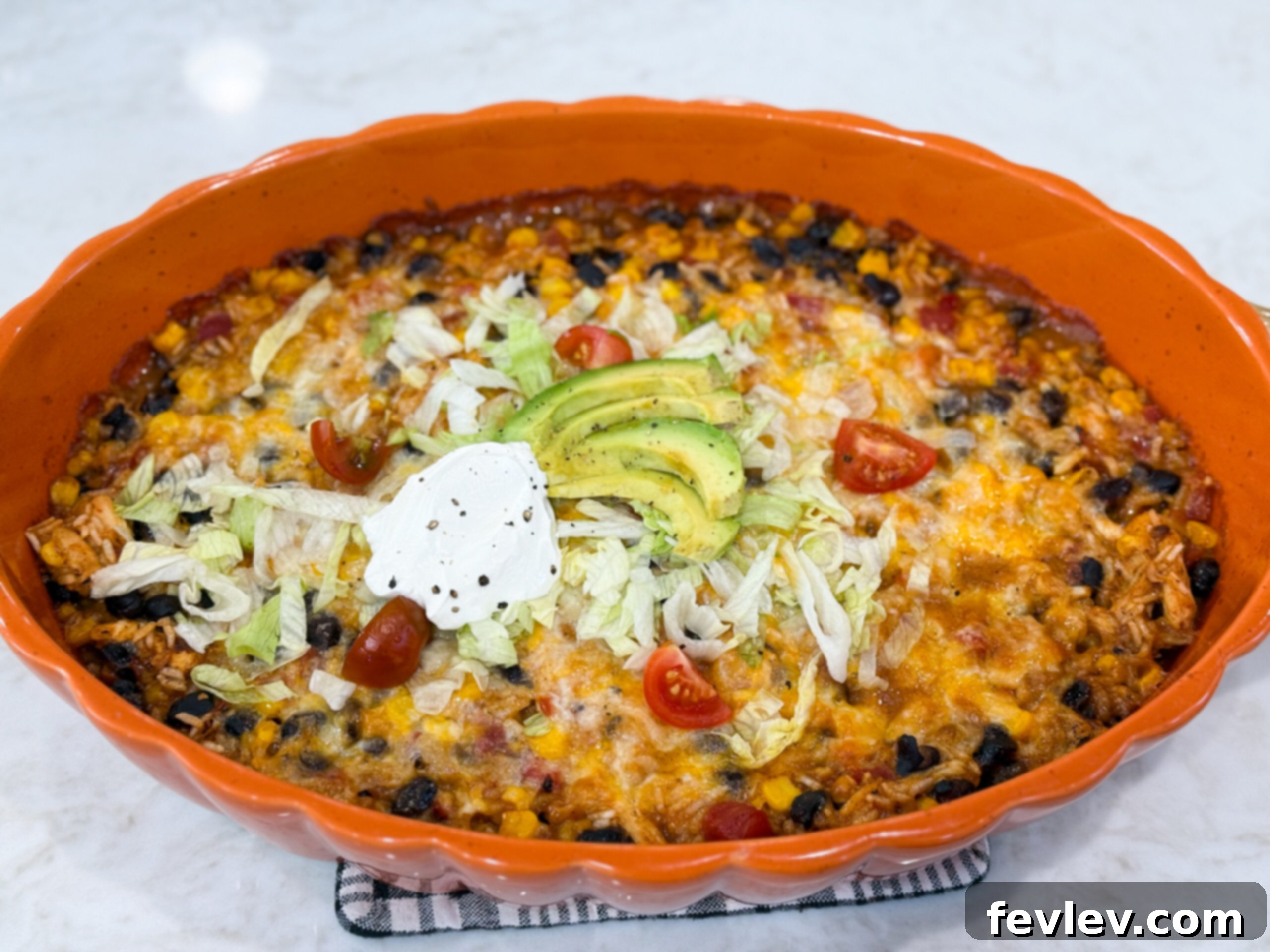 Baked Fiesta chicken casserole, golden and bubbly with melted cheese, topped with vibrant cilantro and diced tomatoes