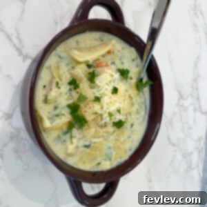 One-Pot White Chicken Lasagna Soup, garnished with cheese