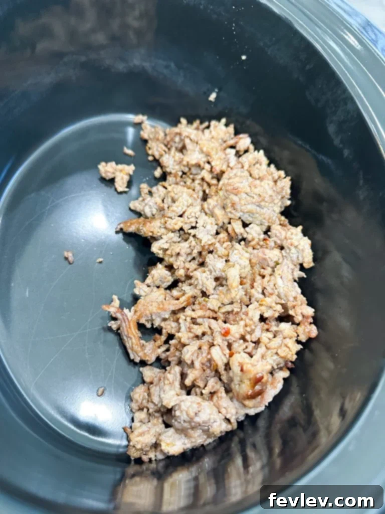browning Italian sausage in a skillet for slow cooker baked ziti