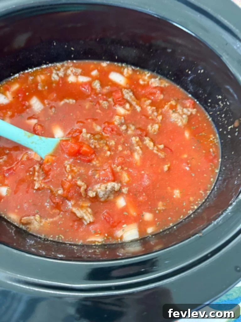 combining ingredients in a slow cooker for baked ziti