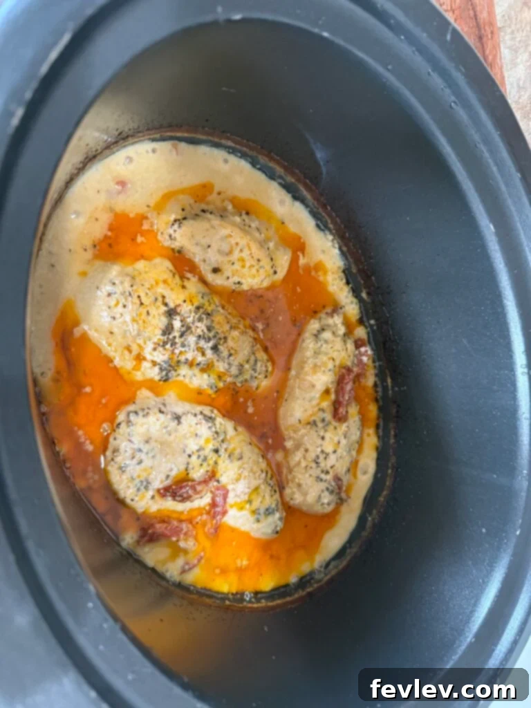 A delicious Slow Cooker Marry Me Chicken dish, featuring tender chicken in a creamy sauce with sun-dried tomatoes, served over pasta.