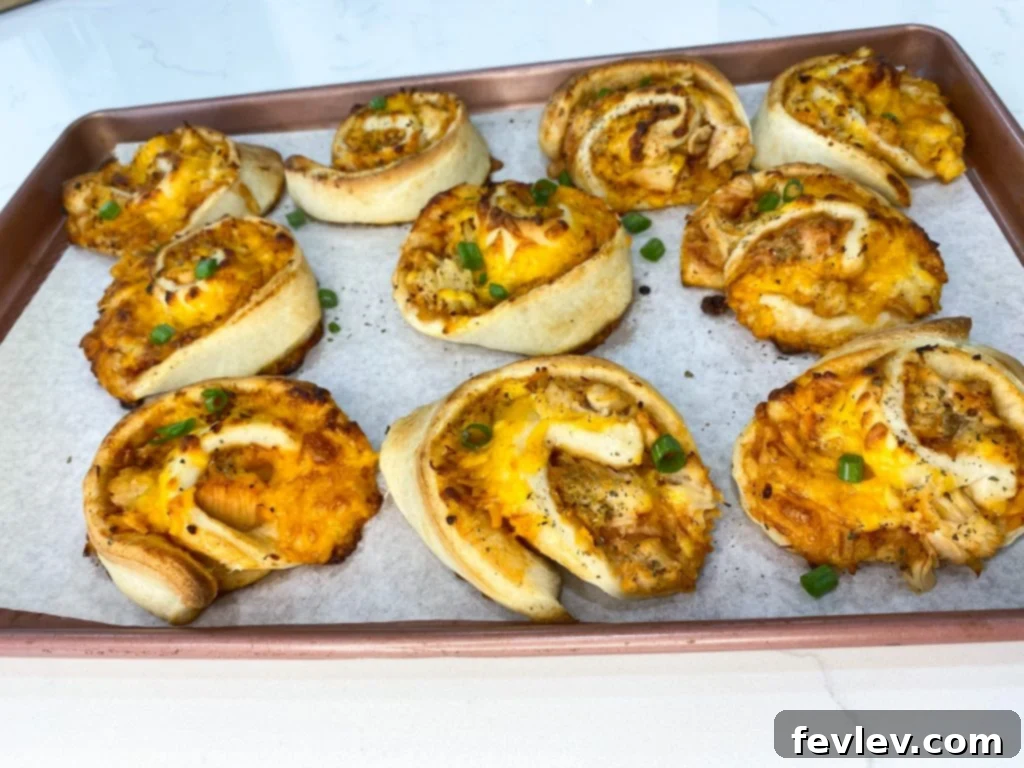 Smoky BBQ Chicken Pinwheels 2 Golden-brown BBQ Chicken Roll Ups fresh out of the oven, sprinkled with green onions