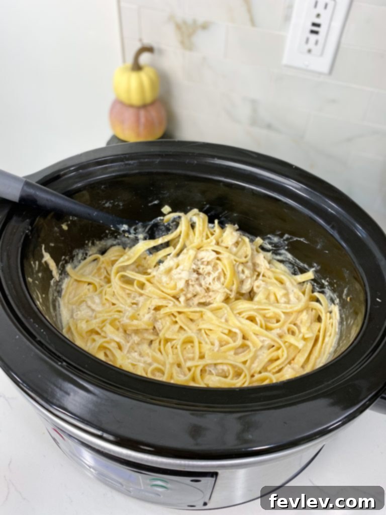 A bowl of Slow Cooker Olive Garden Chicken Pasta garnished with fresh parsley