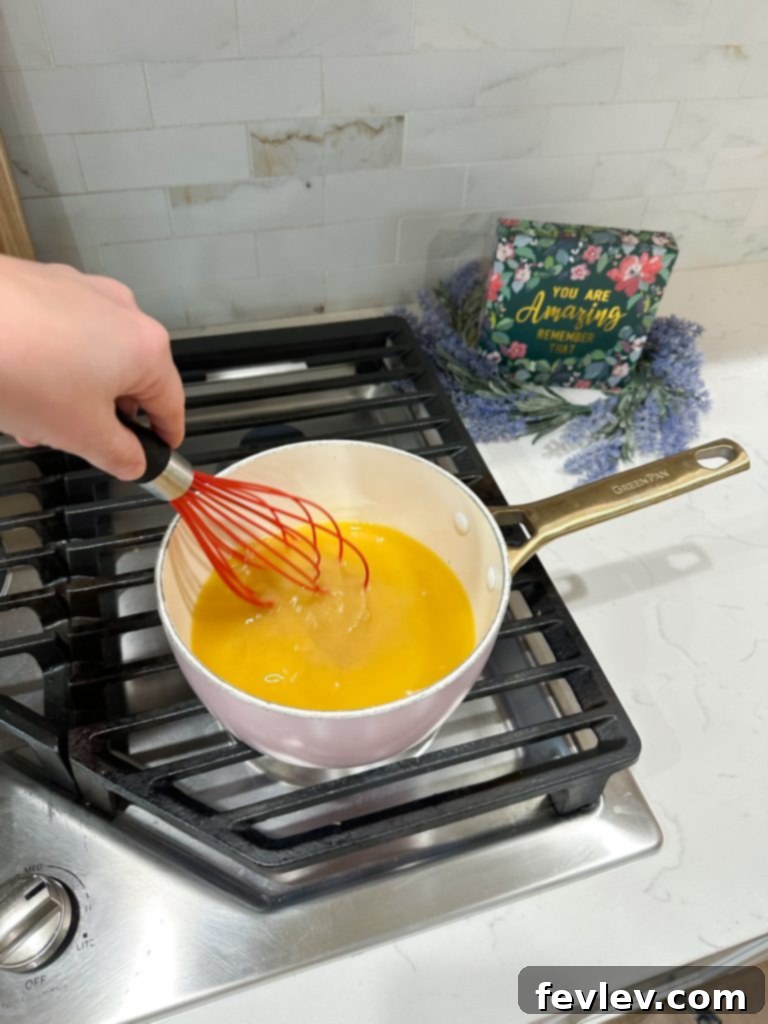 Whisking sugar and orange juice in a saucepan for cranberry sauce
