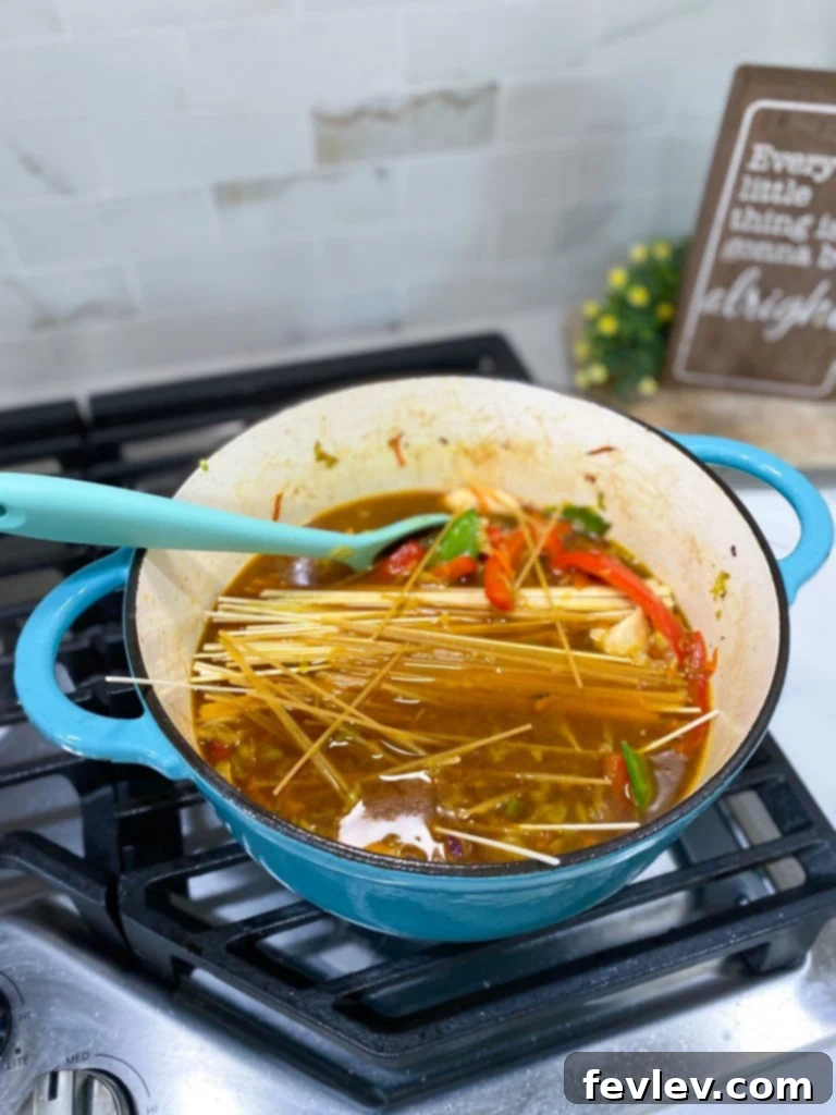 Close-up of fresh ingredients for chicken chow mein: carrots, bell pepper, snow peas, cabbage, and noodles
