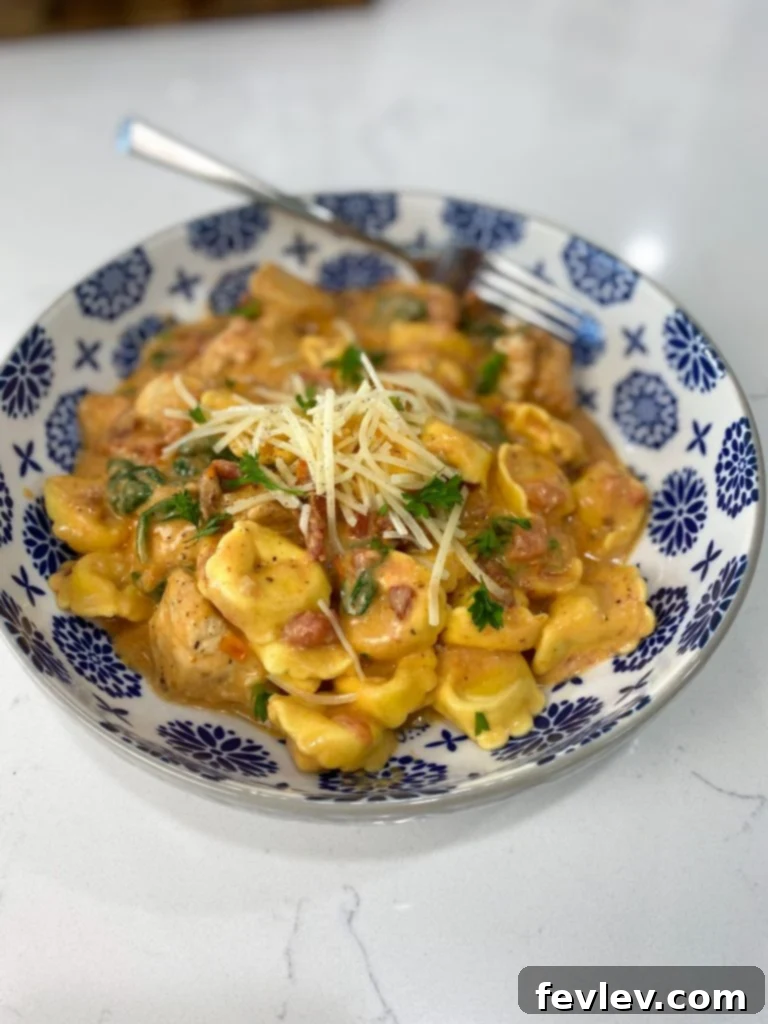 Serving bowl of Sun-Dried Tomato Tortellini, garnished with fresh herbs
