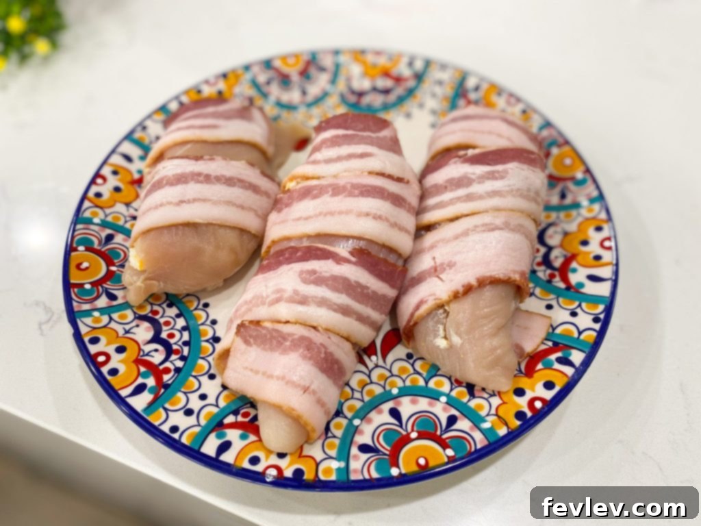 Chicken breast stuffed with cheese and wrapped in bacon, ready for baking
