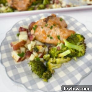 A beautifully plated pork chop sheet pan dinner with a golden-brown pork chop, roasted broccoli, and potatoes.