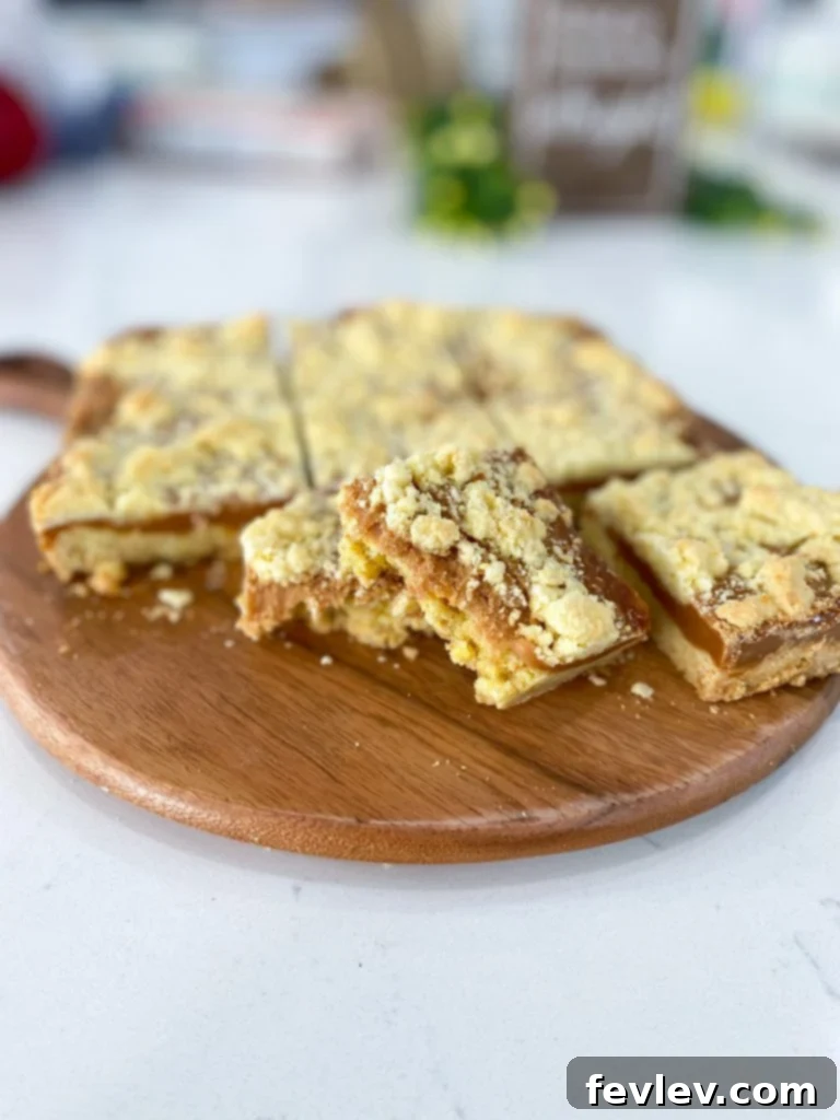 Golden Caramel Dream Bars 2 Delicious Caramel Butter Bars with a golden crumble topping, cut into squares on a cooling rack.