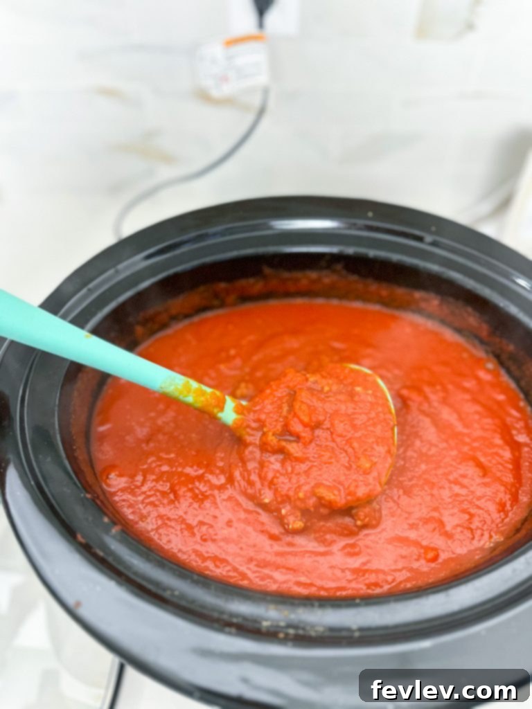 All the ingredients for slow cooker spaghetti sauce laid out on a kitchen counter, ready for preparation.