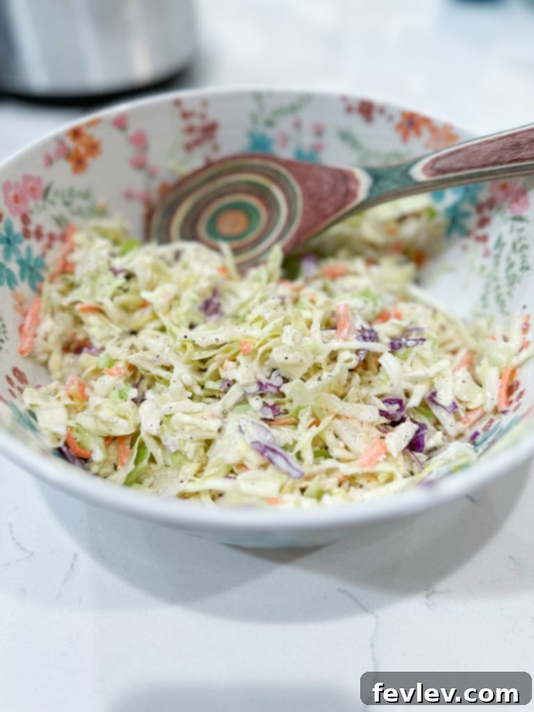 Close-up shot of creamy classic coleslaw in a bowl, showing the crisp cabbage and rich dressing, ready for serving.