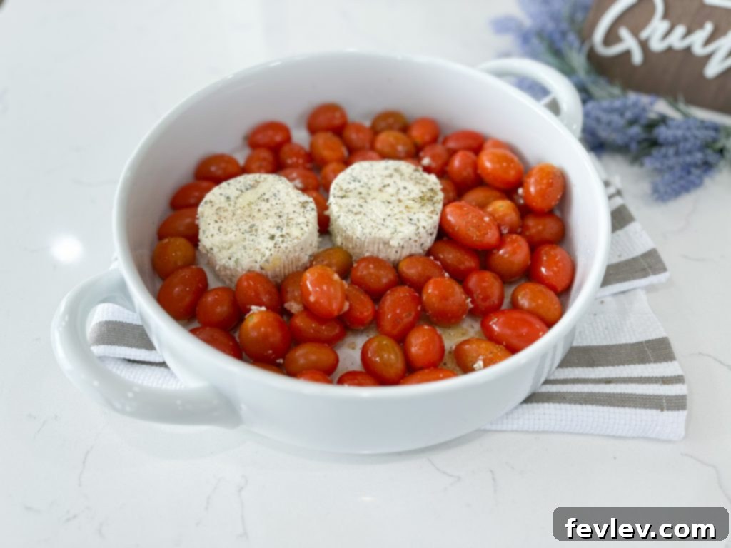 Ingredients for Boursin Cheese Pasta spread out on a counter, including Boursin cheese, cherry tomatoes, and pasta
