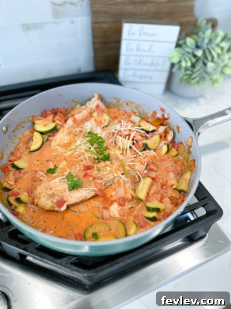 One-Pan Creamy Chicken with Zucchini and Tomatoes 3 A selection of fresh and flavorful ingredients laid out for a Creamy Chicken Skillet, including sliced zucchini, diced onions, and herbs.