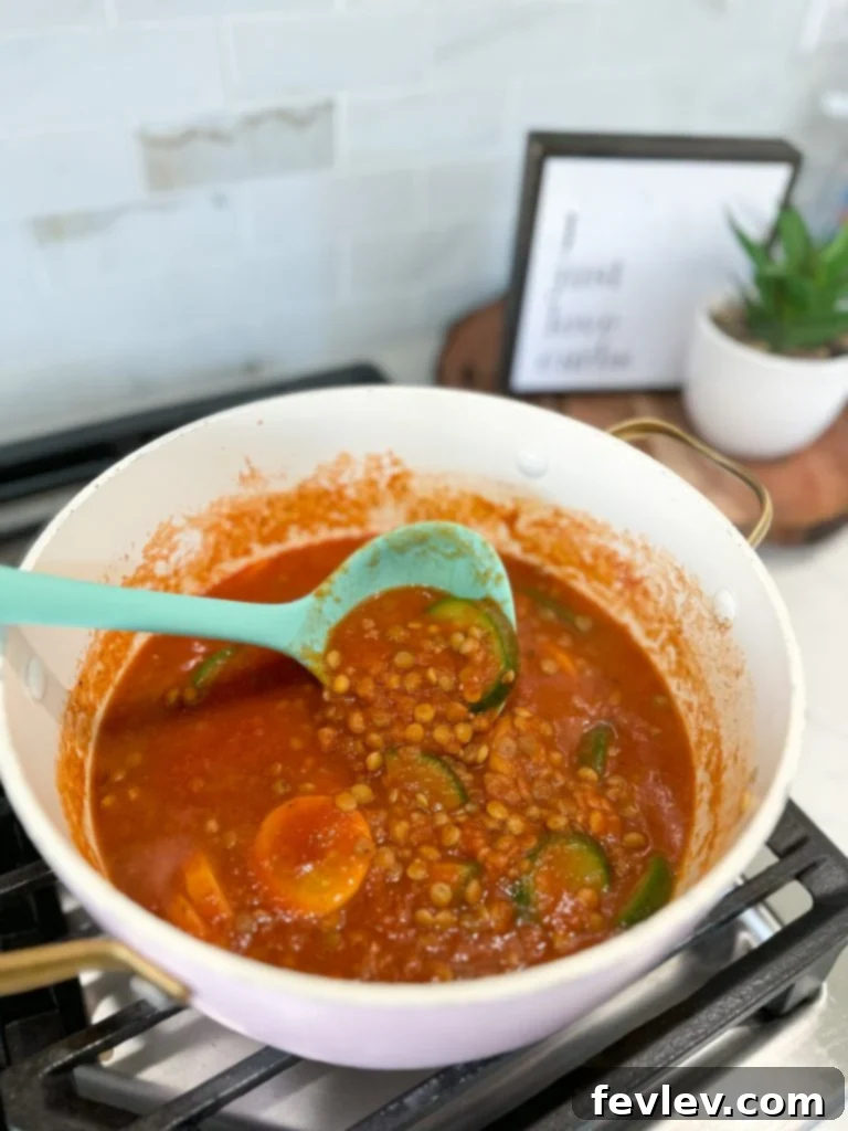 The simmering lentil sauce in a pot, ready to be combined with pasta.