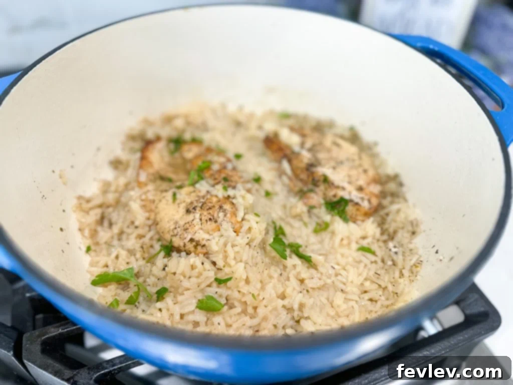 Chicken breasts searing in a Dutch oven with butter and olive oil for the One Pot Lemon Chicken and Rice recipe.