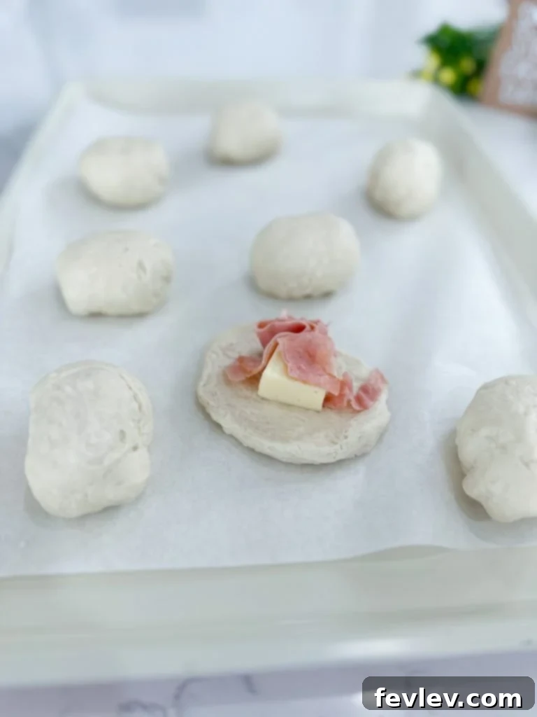 Flattened refrigerated biscuits on a baking sheet, ready for filling.